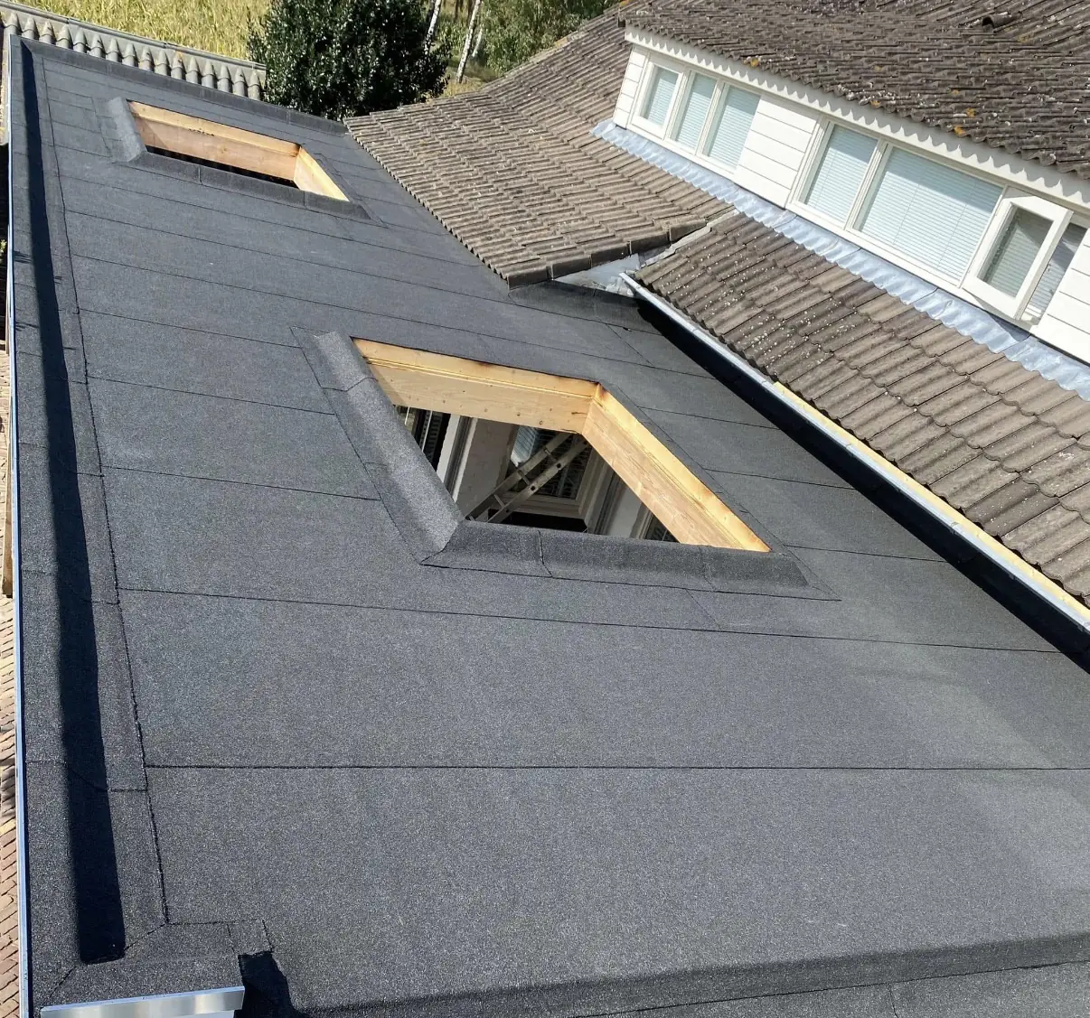 Nieuwe bitumen dakbedekking met dakkapellen door dakdekker Veilig Dak Nederland